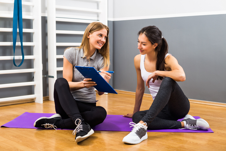 Woman and her franchise broker are having conversation at the gym about opportunities.