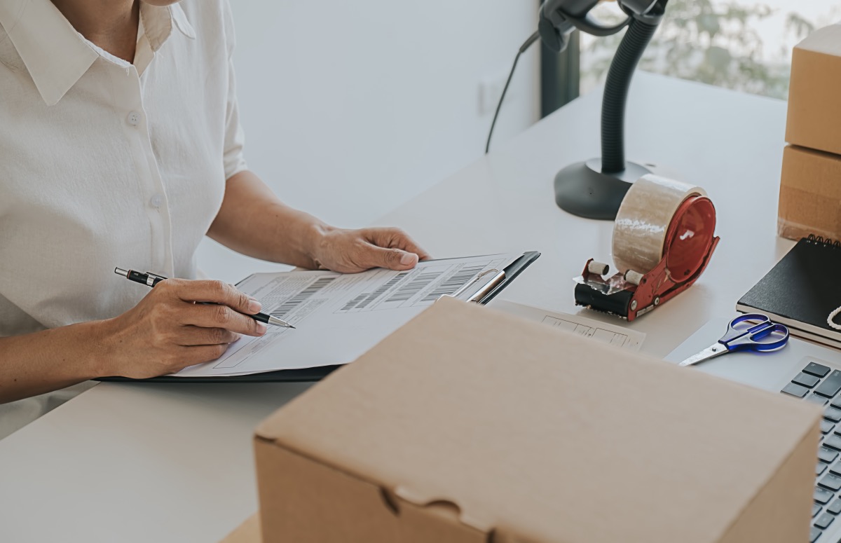 Checkout desk of a package franchise a woman helps a customer ensure their package is sent when and where it needs to go.